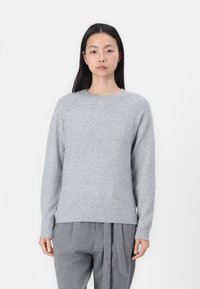 Grauer Strickpullover mit geripptem Rundhalsausschnitt und Bündchen, ausgestattet mit einer weichen Textur und einem lässigen Schnitt, kombiniert mit grauen Hosen.