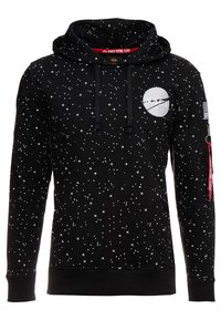 Felpa nera con motivo a stelle bianche, logo NASA sul petto, tasca a marsupio, cordini e tasca laterale con zip e etichetta rossa.