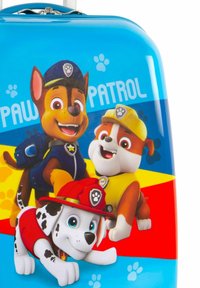 Maleta de tamaño infantil con personajes de perros animados en un vibrante diseño azul. Incluye acentos en rojo, amarillo y naranja con patrones de huellas de patas.