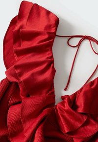 Tissu rouge avec une texture froncée et de fines bretelles à nouer, probablement une partie d'un vêtement, présenté sur un fond clair.