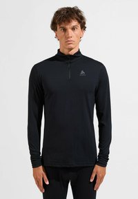 Schwarzes langärmliges Sportoberteil mit einem Halskragen mit halbem Reißverschluss und einem Logo auf der Brust, aus glattem, leichtem Material und mit schmaler Passform.