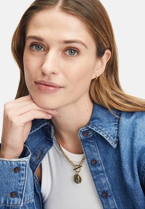 Jeansjacke mit durchknöpfbarer Vorderseite, hellblau. Weißes Tanktop darunter. Goldene Kettenhalskette mit rundem Anhänger. Glatte Textur.