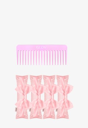 Peigne en plastique rose avec de larges dents portant l'inscription "GLOV" au-dessus de cinq élastiques à cheveux en satin rose, chacun orné d'un nœud.