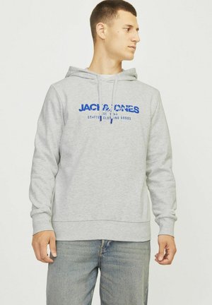 Gray hoodie made of fleece material, featuring a kangaroo pocket, drawstring hood, and blue printed logo on the front. Worn with jeans.