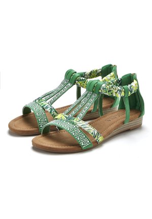Green sandals with decorative straps, featuring floral patterns and rhinestone accents. Textured footbed and low wedge sole for comfort.