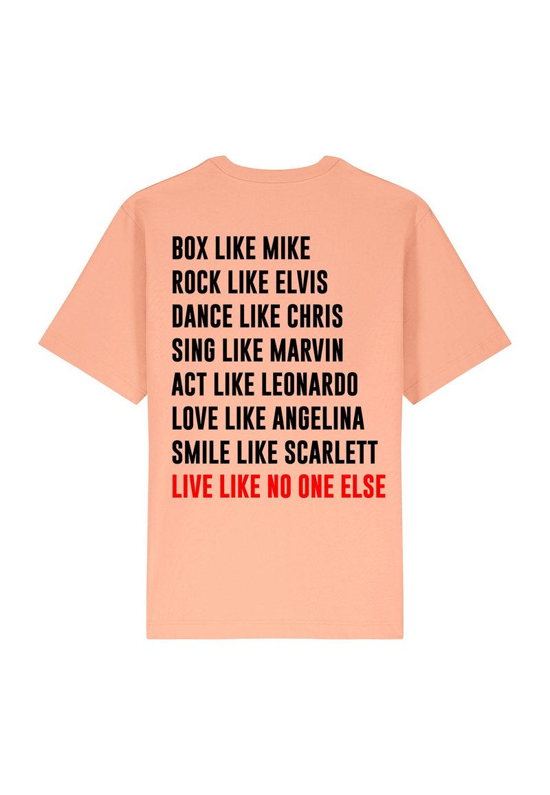 T-shirt pêche avec du texte noir et rouge au dos, illustrant des phrases inspirantes. Col rond et manches courtes. En coton.