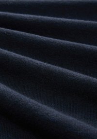 Granatowy materiał z teksturowanym, prążkowanym wzorem, z miękkimi fałdami i gładkim, dzianinowym wyglądem.