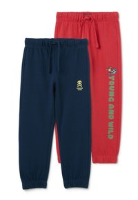 Two pairs of sweatpants: one navy with a yellow skull and "DANGER ZONE," one red with "YOUNG AND WILD" and a cartoon surfer. Elastic waistbands.