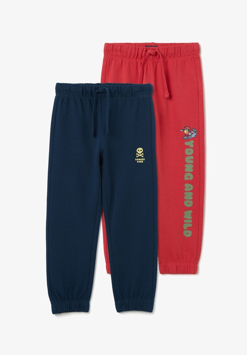 Twee paar joggingbroeken: één in marineblauw met een gele schedel en "DANGER ZONE", de andere in rood met "YOUNG AND WILD" en een cartoon surfer. Elastische taillebanden.