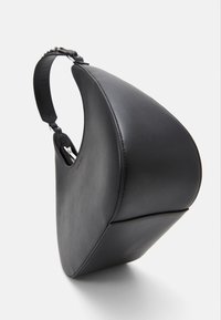 Sorth læderhandtaske med et unikt asymmetrisk design. Den har en glat overflade, en enkelt rem og en synlig lynlås lomme indeni.