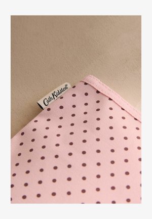 Rosa Stoff mit braunen Punkte und einem eingenähten weißen Etikett mit der Aufschrift "Cath Kidston".