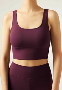 Burgundy sportstop i stretchigt material med fyrkantig halsringning och breda axelremmar, med släta sömmar och kortad design.
