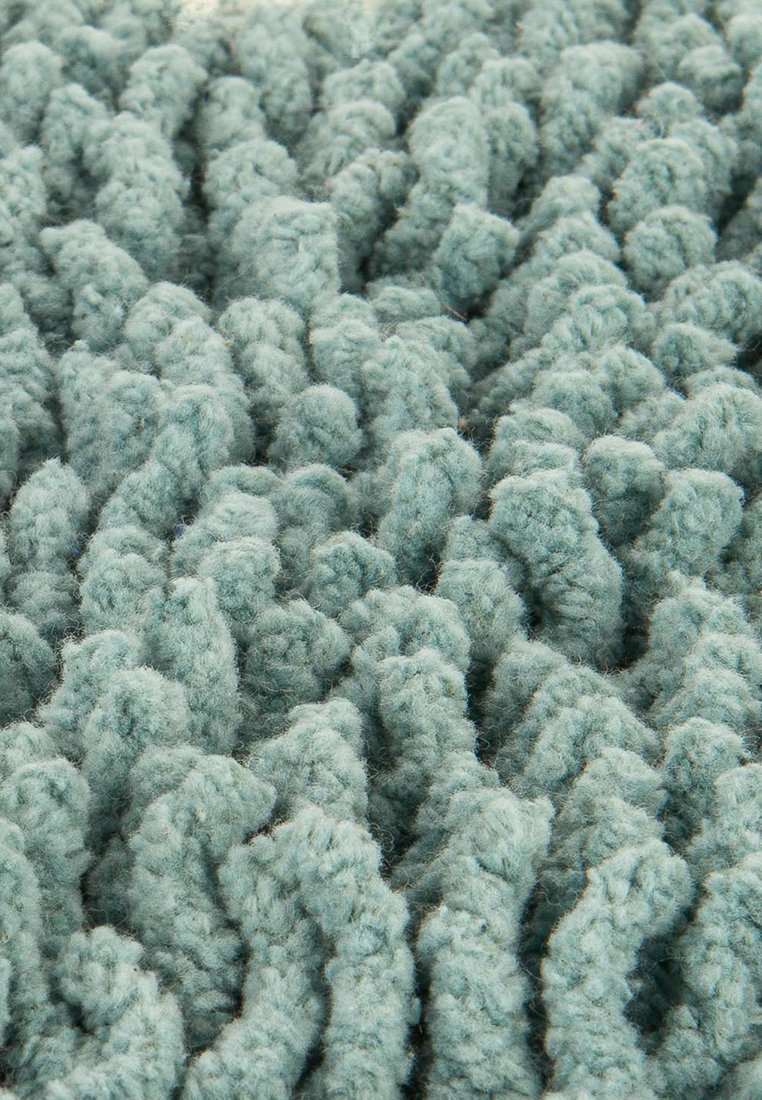 Texturierter Teppich aus weichem mintgrünen Wolle; mit erhöhten, wellenartigen Mustern und einer kuscheligen, taktilen Oberfläche. Ideal, um den Komfort zu erhöhen.