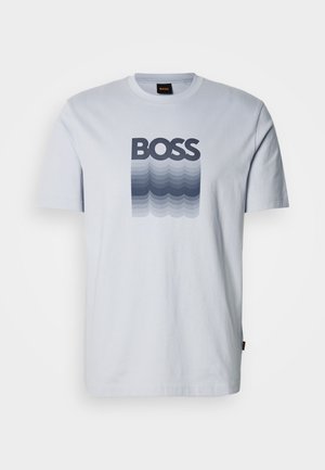 T-shirt en coton bleu clair à manches courtes, avec un logo dégradé allant du bleu foncé vers des nuances plus claires.