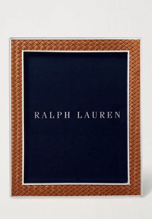 Cadre en cuir tressé marron avec des accents argentés entourant un fond bleu foncé comportant le texte "RALPH LAUREN" en lettres argentées.