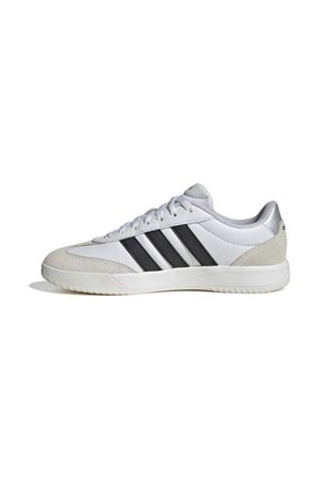 Niedriger weißer Sneaker mit drei schwarzen Streifen an der Seite, weißen Schnürsenkeln und hellgrauen Wildleder-Akzenten an Zehen- und Fersenbereich.