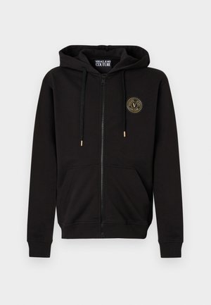 Juodas užsegamas gobtuvas su kapišonu ir priekinių kišenių, kairėje krūtinės pusėje yra nedidelis apvalus Versace Jeans Couture logotipas.