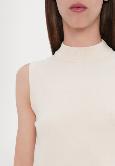 Cream-colored sleeveless top with a high ribbed neckline, featuring a soft knit texture and a fitted silhouette.