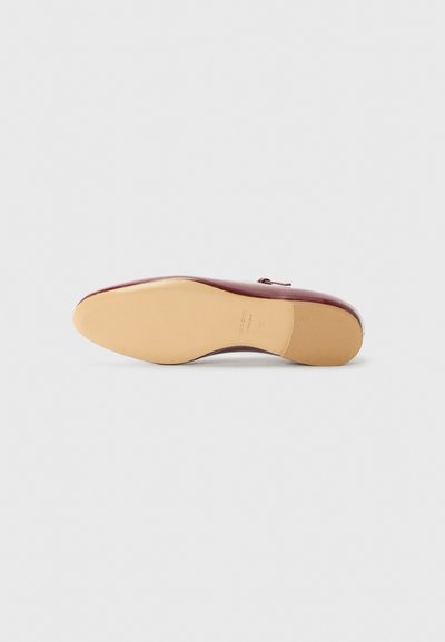 Burgundy leather shoe with a pointed toe, smooth finish, and light beige sole. Features a small heel and a decorative buckle accent.