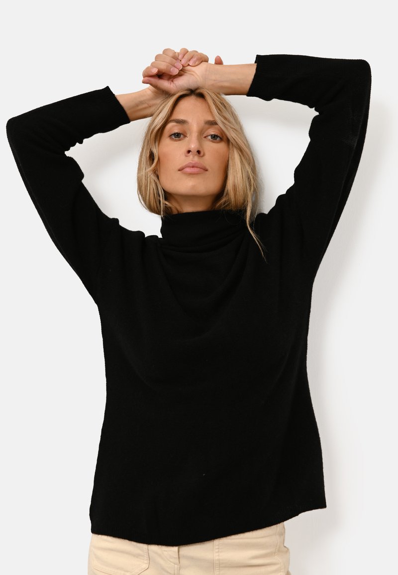 Schwarzer, Rollkragenpullover mit lockerer Passform und langen Ärmeln. Weicher, strukturierter Stoff mit glatter Oberfläche und minimalen Designdetails.