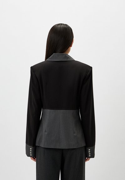 Tailored blazer featuring a black upper section and gray lower panel. Smooth fabric, sharp lapels, and buttoned cuffs with three buttons.