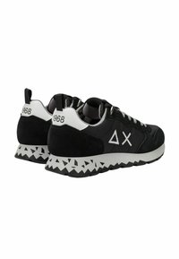 Schwarze Sportschuhe aus Wildleder und Textilmaterialien. Mit einem dreieckigen Muster an der Außensohle und weißen Akzenten. Modellnummer 1968.