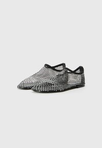 Mesh black and silver shoes with pointed toes, featuring a net-like texture and a slim black rubber sole, designed for breathability.