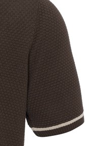 Krátký rukáv z tmavě hnědé strukturované pleteniny s tenkým světlým béžovým pruhem blízko okraje rukávu na bílém pozadí.