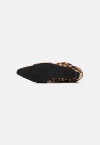 Shoe à talon haut en imprimé léopard avec un design aiguille, un dessus en texture douce et une semelle en caoutchouc avec des rainures de traction pour une meilleure adhérence.
