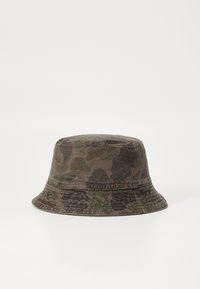 Bucket hat i camouflage-mønster med nuancer af grøn og brun. Fremstillet af tekstureret stof med en bred, fleksibel skygge.