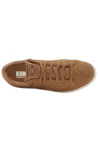Ruskea mokkanahkainen K-Swiss-kenttätyylinen sneaker, jossa on nauhat, brändätty kieli ja valkoinen pohja, nähtynä ylhäältäpäin.