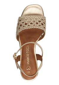 Sandal in tessuto dorato con suola interna imbottita marrone, design con punta aperta e cinturino alla caviglia regolabile con una piccola fibbia in metallo.