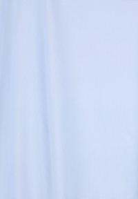 Tissu bleu clair texturé avec un subtil motif de tissage diagonal et des plis doux.