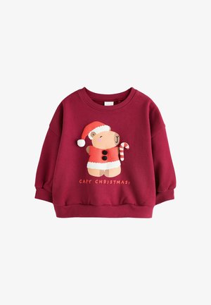 Rød julesweater til børn med en bjørn iført en julemandshue og frakke, der holder en slikstok med teksten "CAPY CHRISTMAS".