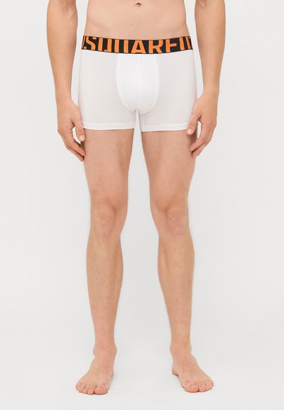 Weiße Boxer-Shorts mit einem elastischen schwarzen Bund, der orangefarbener Text aufweist. Der Stoff wirkt glatt und hat ein enganliegendes Design.