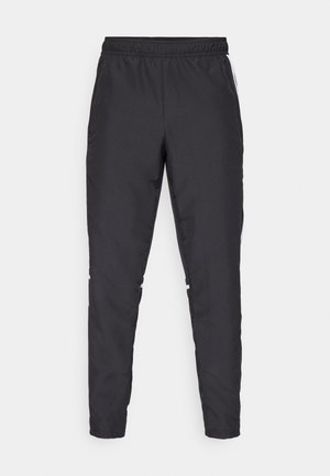 Schwarze Sporthose mit elastischem Bund, schmal zulaufenden Beinen und weißen Seitenelementen. Hergestellt aus synthetischem Material mit glatter Textur.