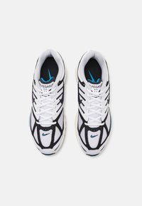 Bílé a černé sportovní běžecké boty s modrými akcenty, prodyšným svrchním materiálem a tkaničkami, pohled shora na bílém pozadí.
