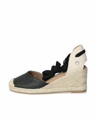 Espadrille cuña en blanco y negro con suela de yute trenzado, tela texturada y diseño con cordones. Acentuada con un pequeño detalle decorativo.
