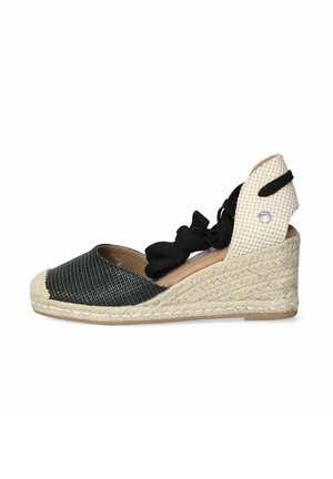 Espadrillas a zeppa bianche e nere con suola in juta intrecciata, tessuto testurizzato e design con lacci. Accentuate da un piccolo dettaglio decorativo.