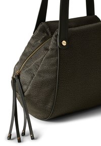 Sac à main en tissu texturé foncé avec une forme triangulaire, des anses en cuir, une fermeture éclair dorée et des glands décoratifs.