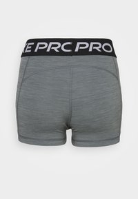 Shorts de compression athlétiques gris avec une ceinture noire portant le texte blanc « NIKE PRO », vus de dos.