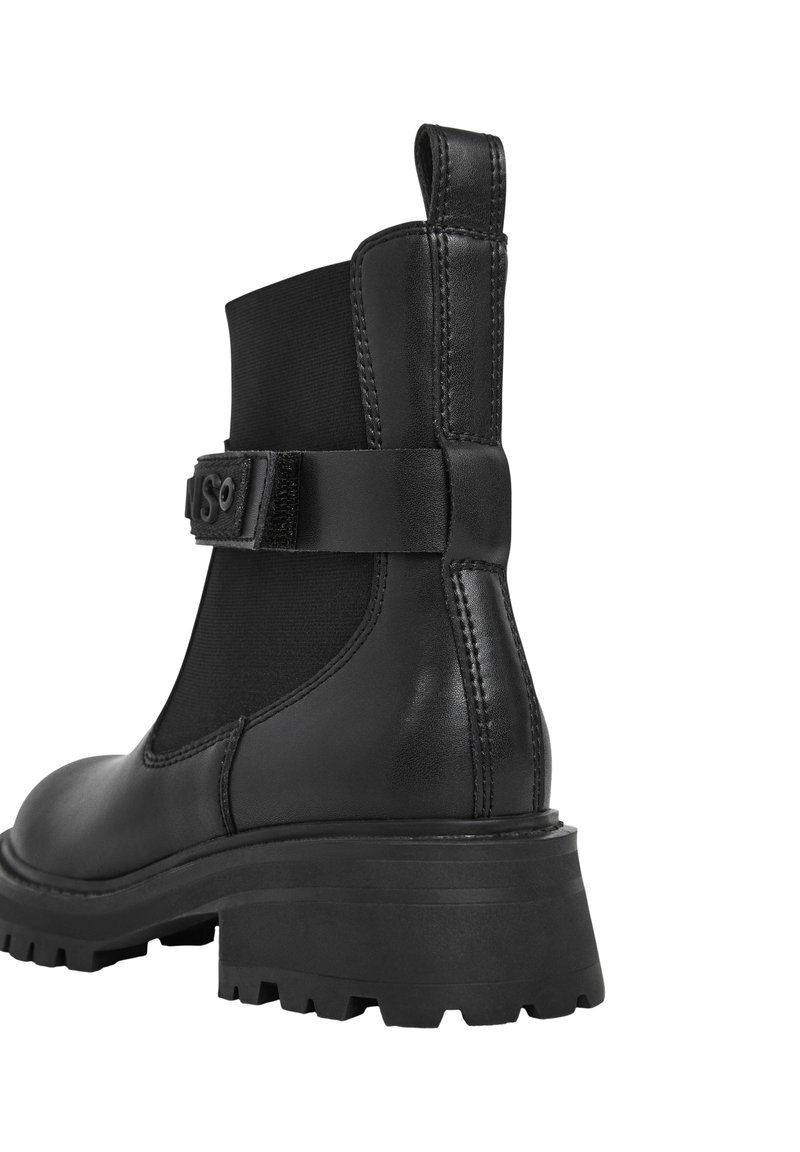 Stivaletto in pelle nera con suola spessa, pannello elastico laterale, linguetta sul tallone e cinturino regolabile con fibbia su sfondo bianco.