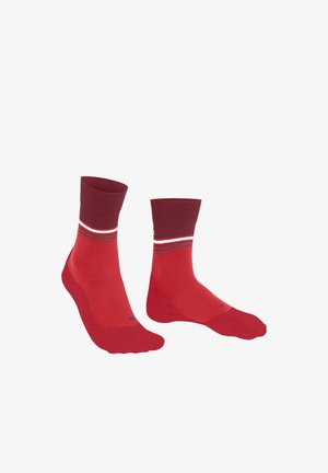 Paar rote Sportsocken mit kastanienbraunen Bündchen und weißen sowie dunkelroten Streifen nahe dem oberen Rand, mit links und rechts auf den Zehen beschriftet.