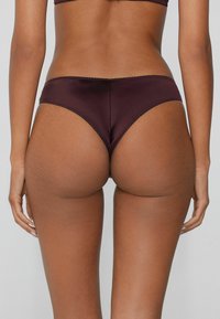 Burgundyer Hipster-Unterwäsche aus glattem, glänzendem Stoff, mit wellenförmigen Kanten und einem tiefen Bund für einen bequemen Sitz.