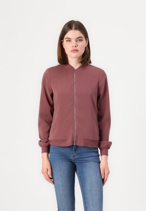 Jakke i bomberstil med glidelås foran i dempet rosa; mykt stoff, ribbede mansjetter og nederkant, sidelommer, minimalistisk design med rund krage.