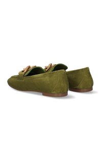 Mocasines de ante verde con punta redonda, que presentan un lazo decorativo y un forro interior en contraste. Diseño de tacón bajo con una suela lisa.