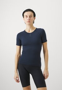 Marineblaue figurbetonte Kurzarmbluse aus weichem Stoff mit Rundhalsausschnitt und minimalen Nähten für Komfort und Flexibilität.