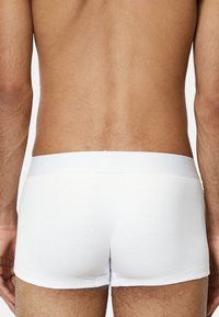 Weiße gerippte Boxershorts mit einem glatten Bund, entworfen für Komfort und Passform, mit einem minimalistischen Stil und klaren Linien.