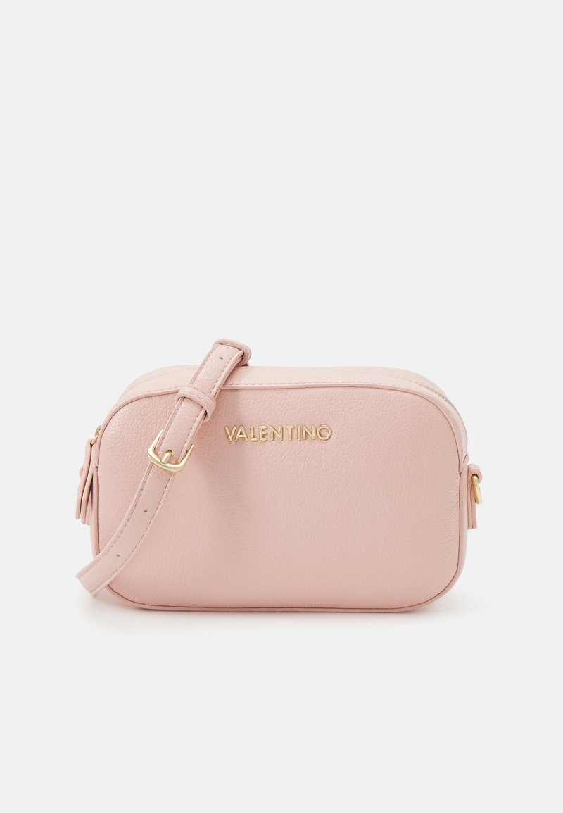 Pink leather crossbody bag with a gold logo, zip closures, and adjustable strap. Smooth texture with subtle stitching detail.