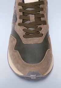 Brązowe i oliwkowozielone sneakersy z zamszu i skóry, z teksturowanymi sznurowadłami oraz subtelnym tonalnym wzorem w zakrzywionym kształcie.